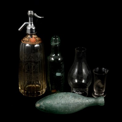 Lot 233 - A quantity of vintage glassware, eye baths, measures, C Cooke of Kettering bottles and Soda Water syphon.