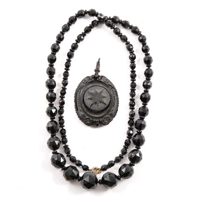 Lot 465 - A jet style faceted bead necklace and a carved oval pendant.