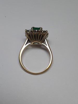 Lot 71 - An emerald and diamond square cluster ring.