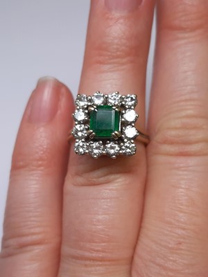 Lot 71 - An emerald and diamond square cluster ring.
