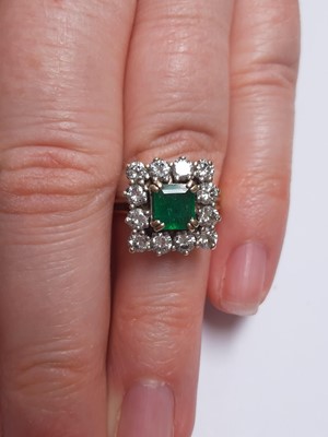 Lot 71 - An emerald and diamond square cluster ring.
