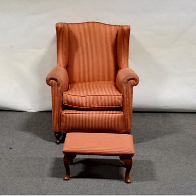 Lot 494 - Traditional wing-back easy chair and a footstool