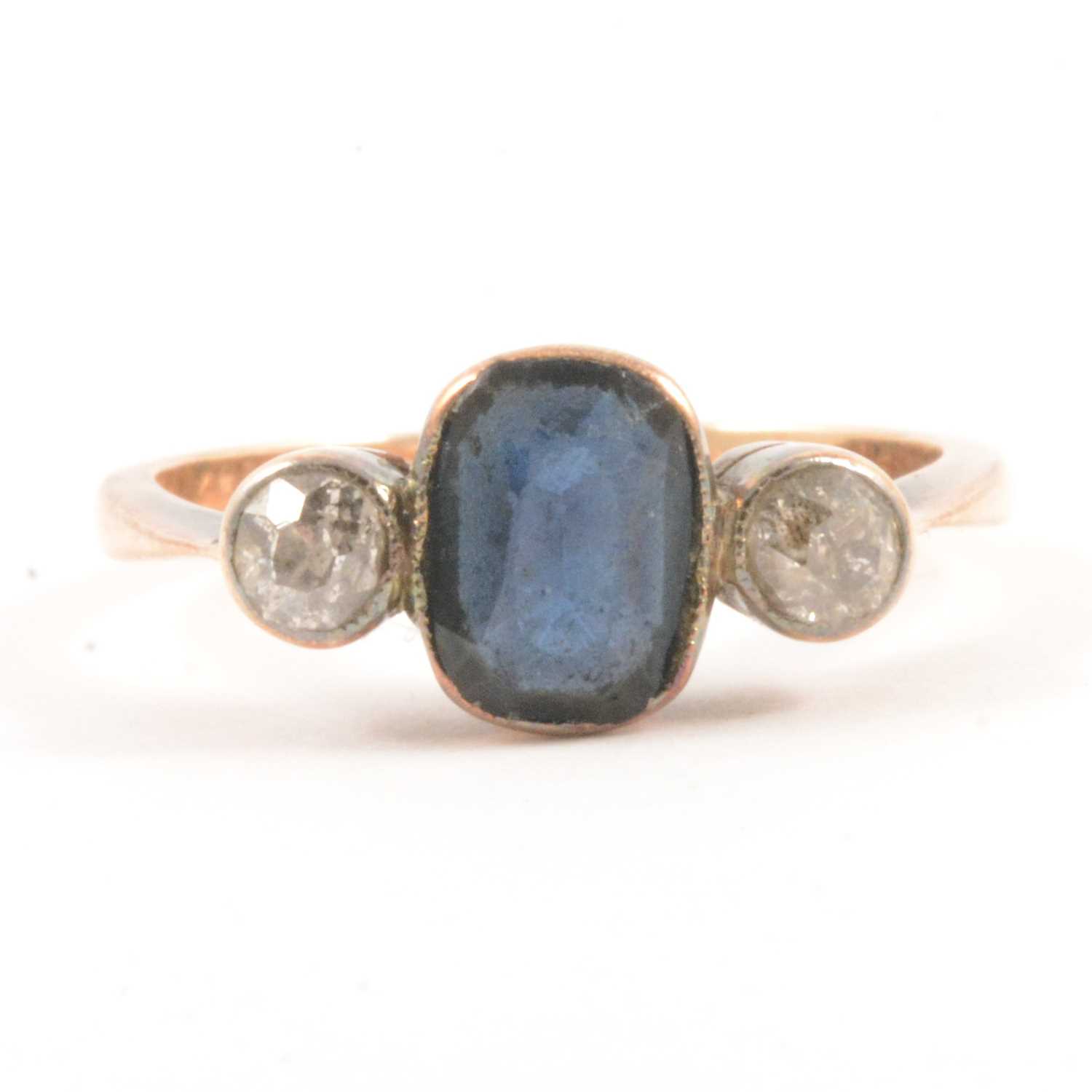 Lot 55 - A diamond and blue stone ring.