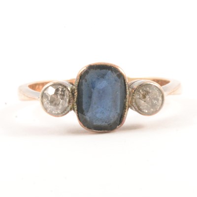 Lot 55 - A diamond and blue stone ring.