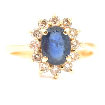 Lot 228 - A sapphire and diamond cluster ring.