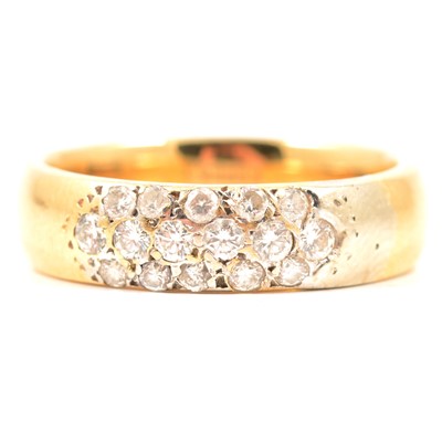 Lot 14 - An 18 carat yellow gold band set with diamonds.