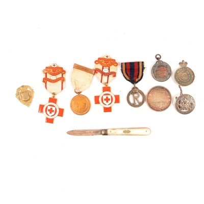 Lot 280 - A collection of silver medallions, badges, and a silver and mother-of-pearl fruit knife