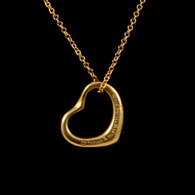 Lot 94A - Elsa Peretti for Tiffany - an 18 carat yellow gold open heart pendant and chain.