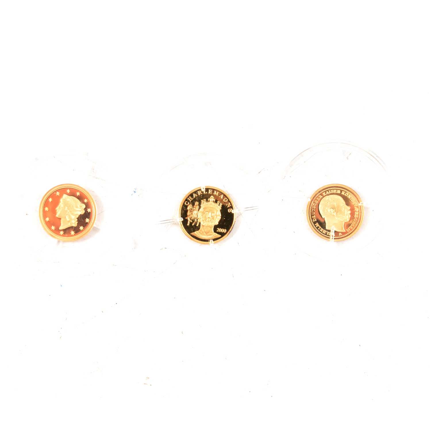 Lot 231 - A 14 carat gold proof replica of the 1849-C Liberty Dollar, and two 8 carat gold coins.
