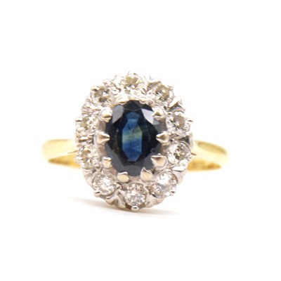 Lot 60 - A sapphire and diamond cluster ring.