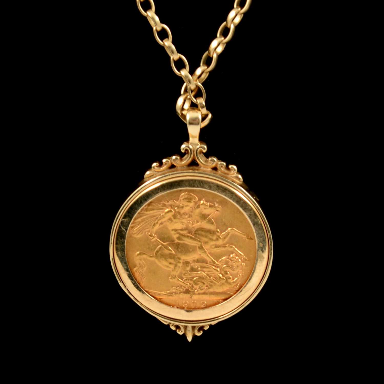 A George V full gold sovereign and 9ct gold watch chain, the sovereign  dated 1913 in