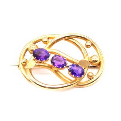 Lot 222 - An amethyst knot design brooch.