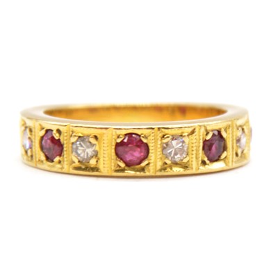 Lot 42 - A ruby and diamond half eternity ring.