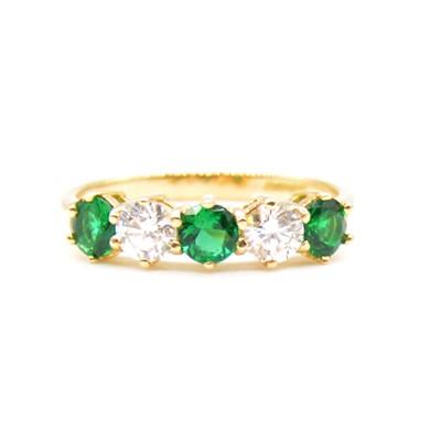 Lot 36 - An emerald and diamond half hoop ring.