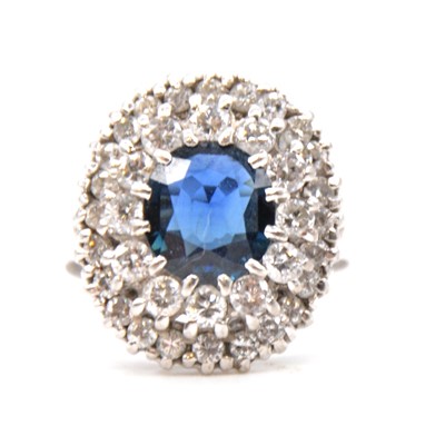 Lot 59 - A sapphire and diamond oval cluster ring.