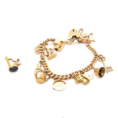 Lot 174 - A gold charm bracelet with eleven charms and a bloodstone seal.