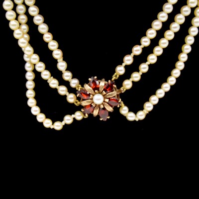 Lot 186 - A cultured pearl triple row choker necklace with cultured pearl and garnet clasp.