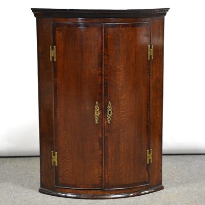 Lot 499 - George III oak and mahogany bowfront hanging corner cupboard