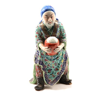 Lot 21 - Chinese porcelain and polychrome decorated figure of a merchant