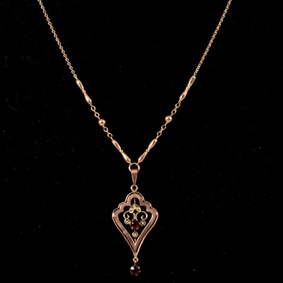 Lot 198 - A garnet and seed pearl pendant on fancy link chain.