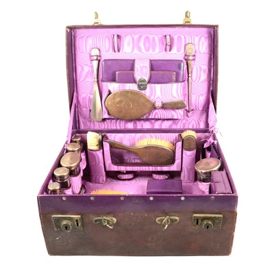 Lot 275 - A leather travelling vanity case with silver topped jars and brushes.