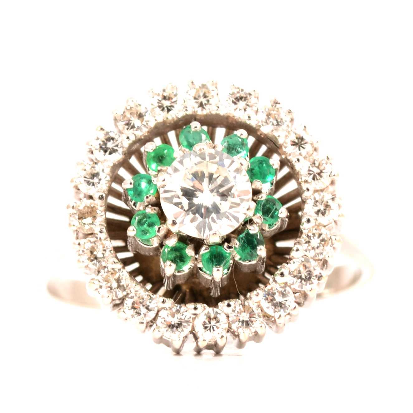 Lot 30 - An emerald and diamond reverse cluster ring.