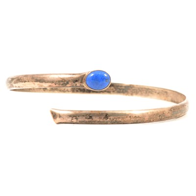 Lot 206 - A silver upper arm bangle set with an oval cabochon cut lapis lazuli.