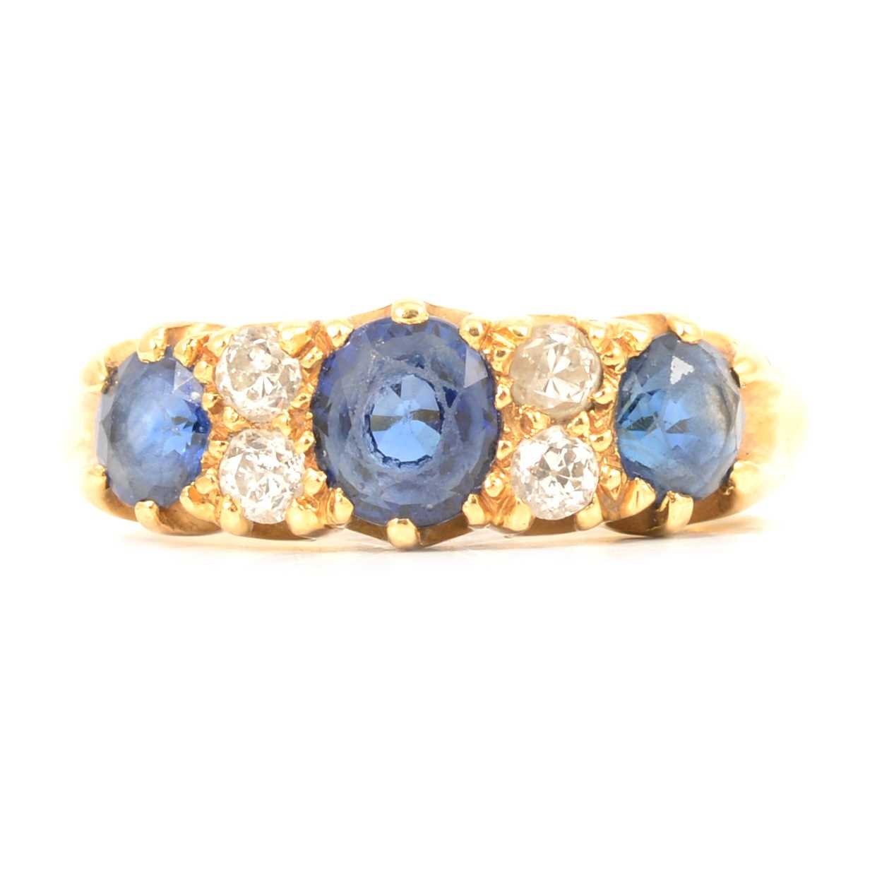 Lot 20 - A sapphire and diamond half hoop ring.