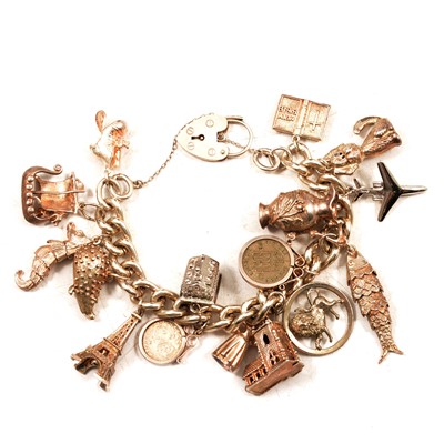 Lot 410 - A silver curb link bracelet and sixteen charms.