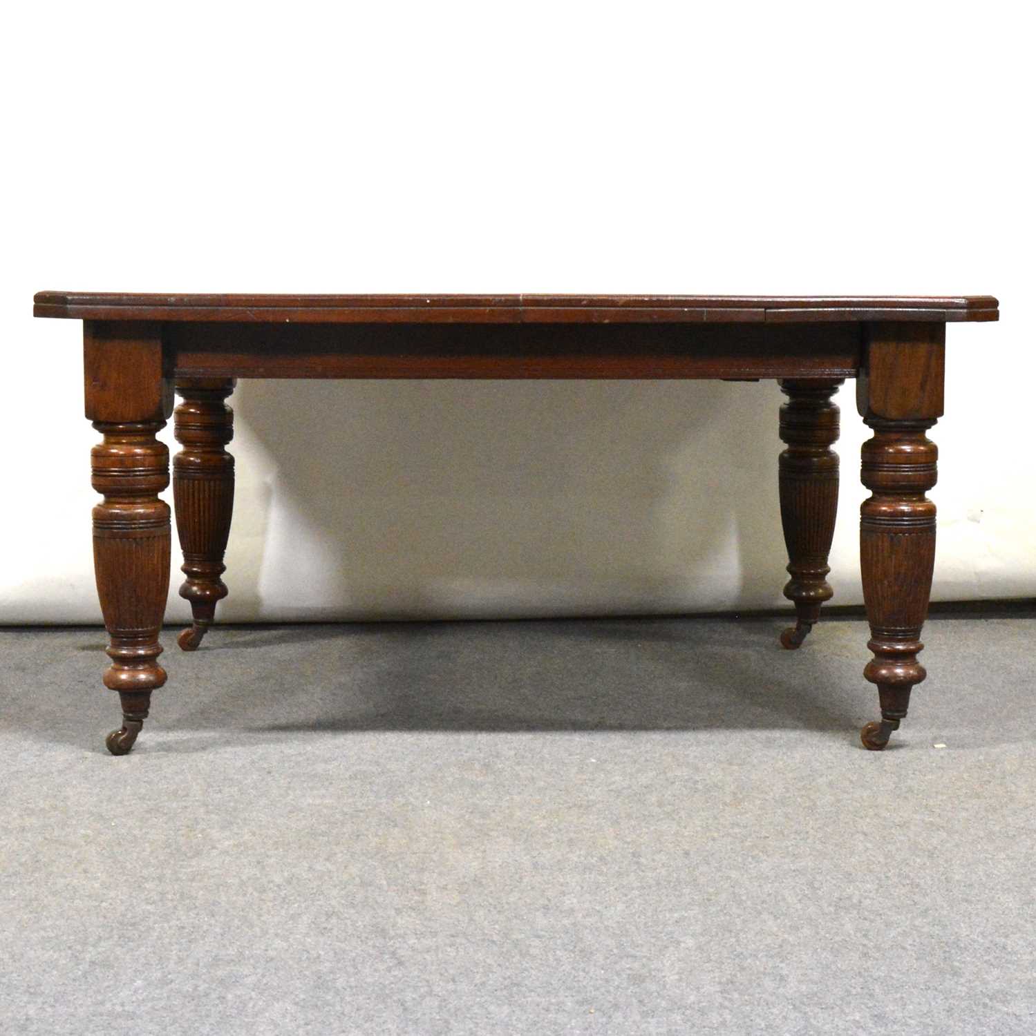Lot 444 - Edwardian oak wind-out dining table,