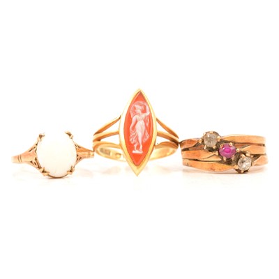 Lot 93 - A carved shell cameo ring, a ruby and diamond triple shank ring, and an opal ring.
