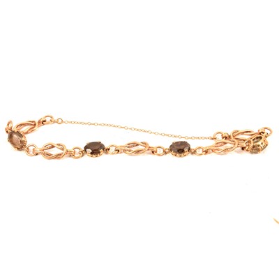 Lot 233 - A 9 carat yellow gold bracelet set with four oval mixed cut smoky quartz.