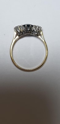 Lot 17 - A sapphire and diamond three stone ring.