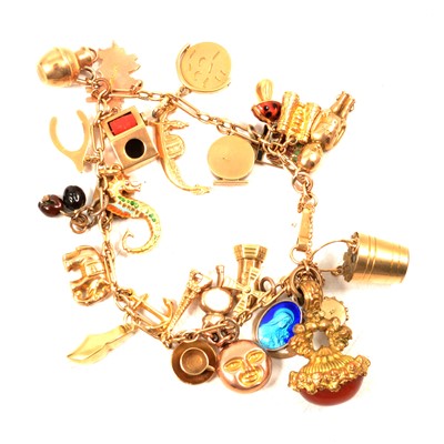 Lot 235 - A gold charm bracelet with metal and gold charms.