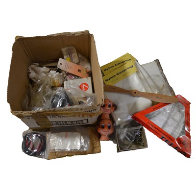 Lot 524 - A box containing model aircraft parts and accessories, including nylon covering, props, etc.