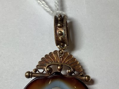 Lot 186 - A carved banded agate and cultured pearl shell pendant.