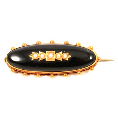 Lot 193 - An oval onyx, seed pearl and yellow metal mourning brooch with locket back.