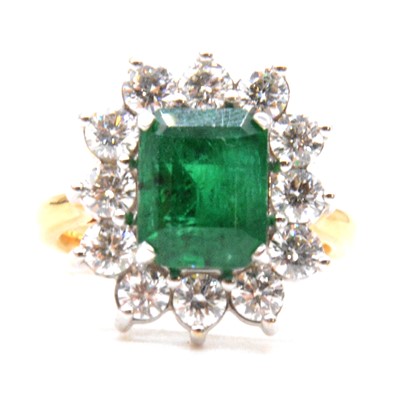 Lot 28 - An emerald and diamond cluster ring.