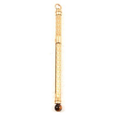 Lot 341 - A 9 carat yellow gold swivel stick with tiger's eye bead.