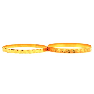 Lot 220 - Two yellow metal slave bangles, one marked 21K.