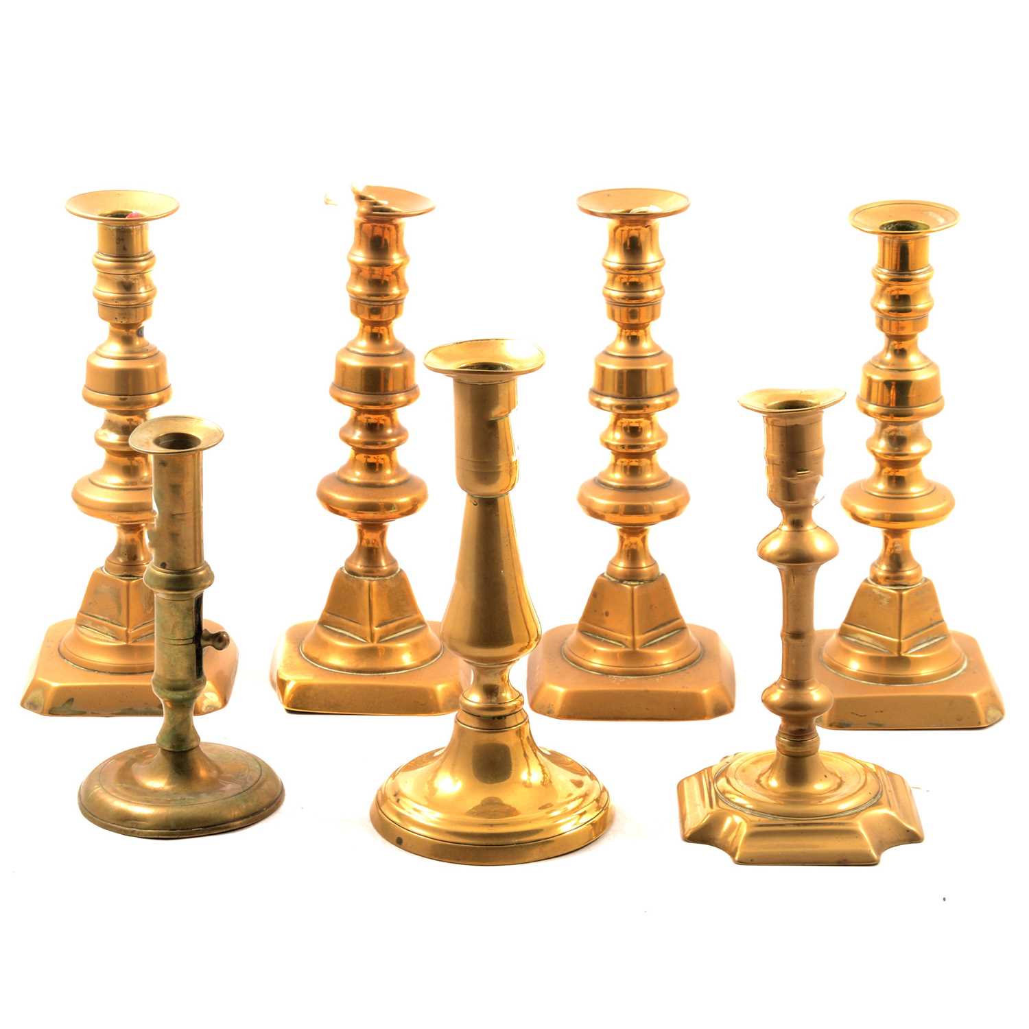 Lot - SET OF FOUR GEORGIAN BRASS PUSH-UP CANDLESTICKS