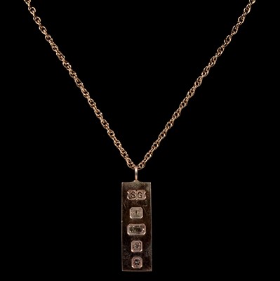 Lot 207 - A 9 carat yellow gold ingot pendant and chain.