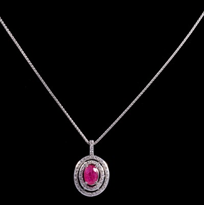 Lot 191 - A ruby and diamond pendant on a white metal chain.