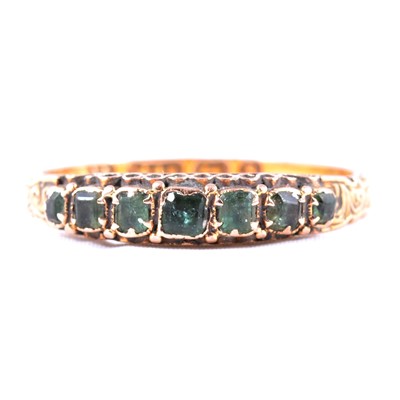 Lot 34 - A green stone half eternity ring.