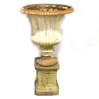 Lot 473 - Cast iron fluted garden urn, on an associated stone plinth