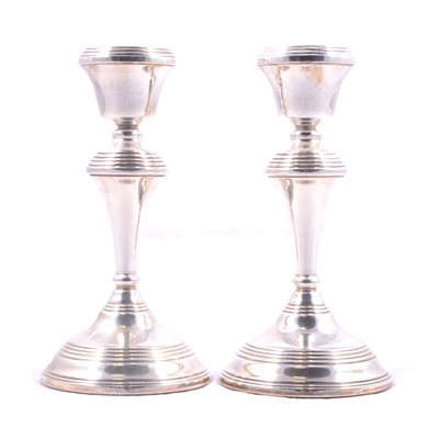 Lot 403 - A pair of silver candlesticks with filled bases.