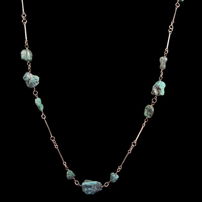 Lot 320 - A turquoise matrix bead necklace with 9 carat yellow gold bars.